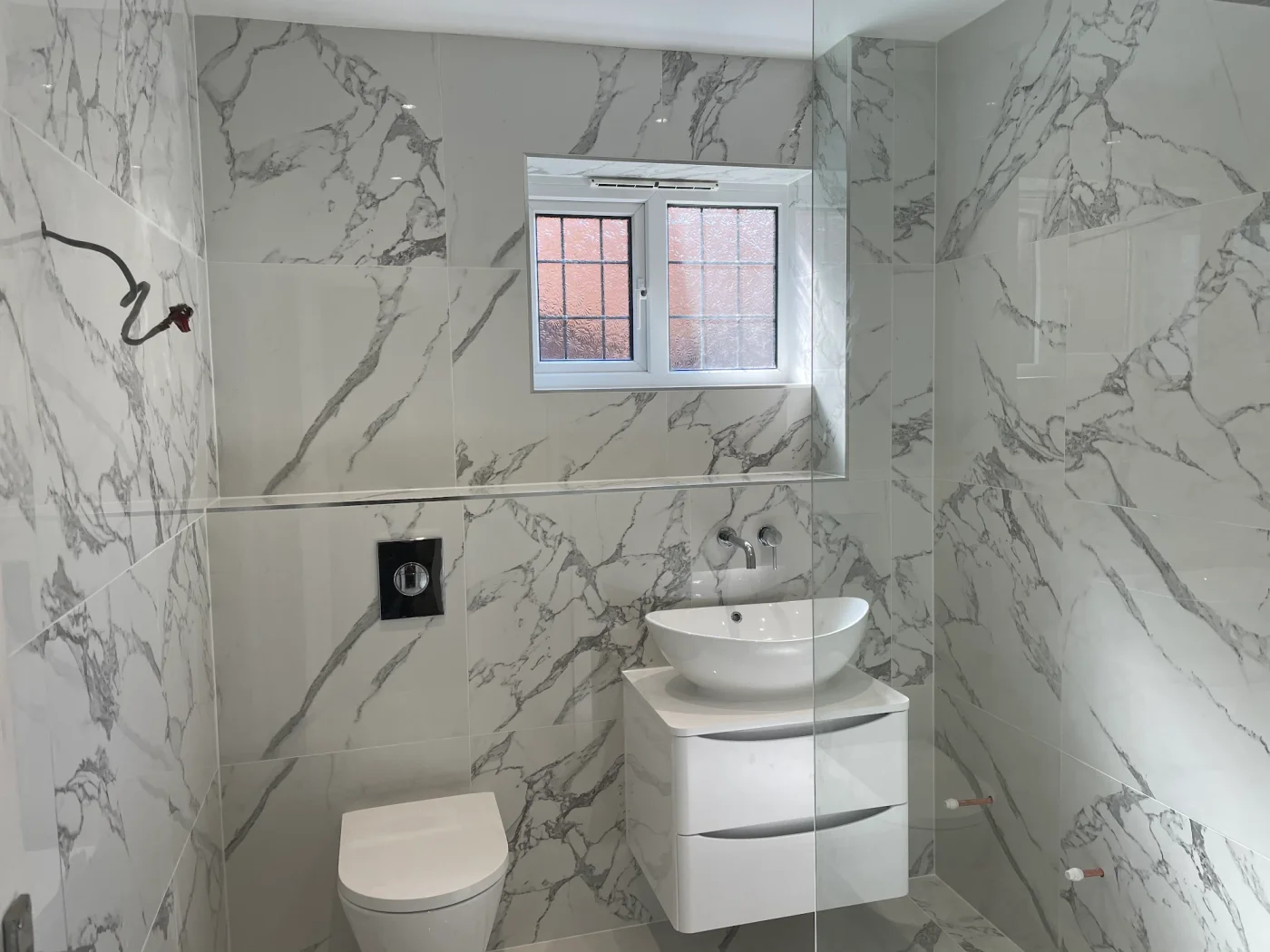 Marble-effect shower room with a curved vanity and countertop basin