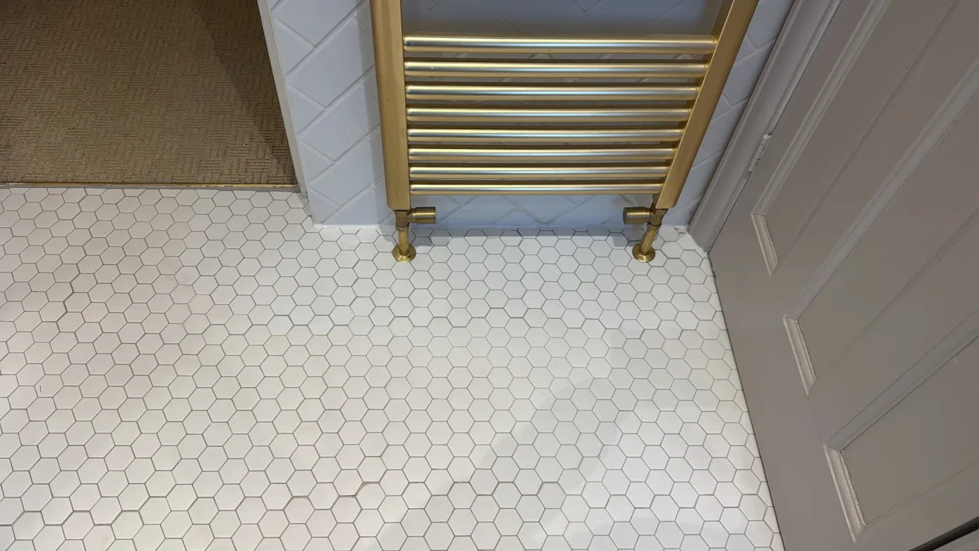 Repaired and retiled floor beneath the brass towel rail
