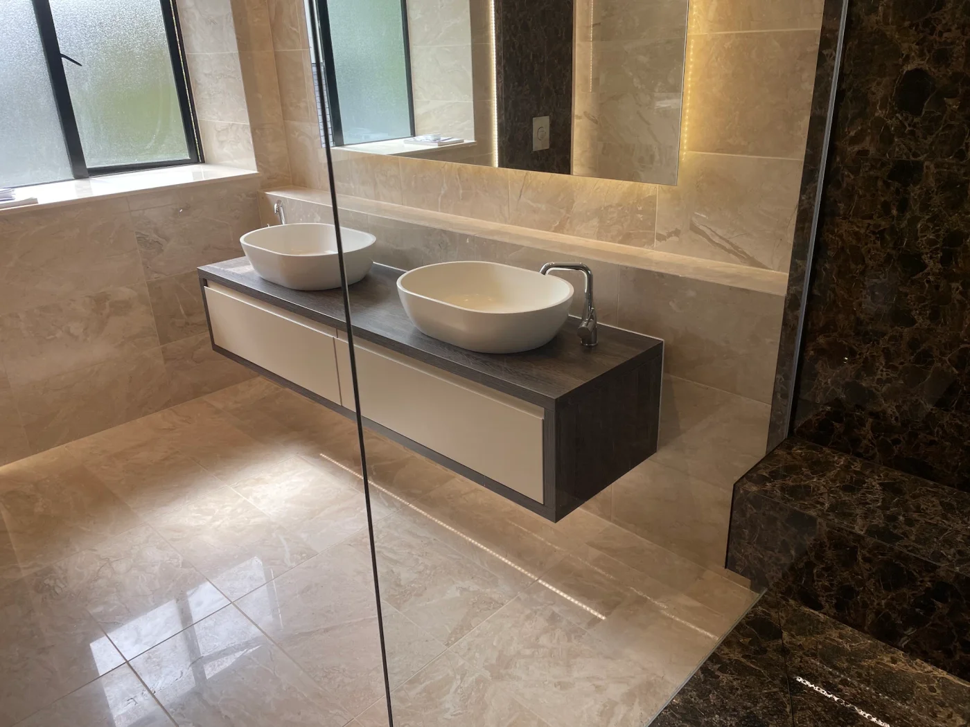 Floating double vanity seen through the glass shower screen