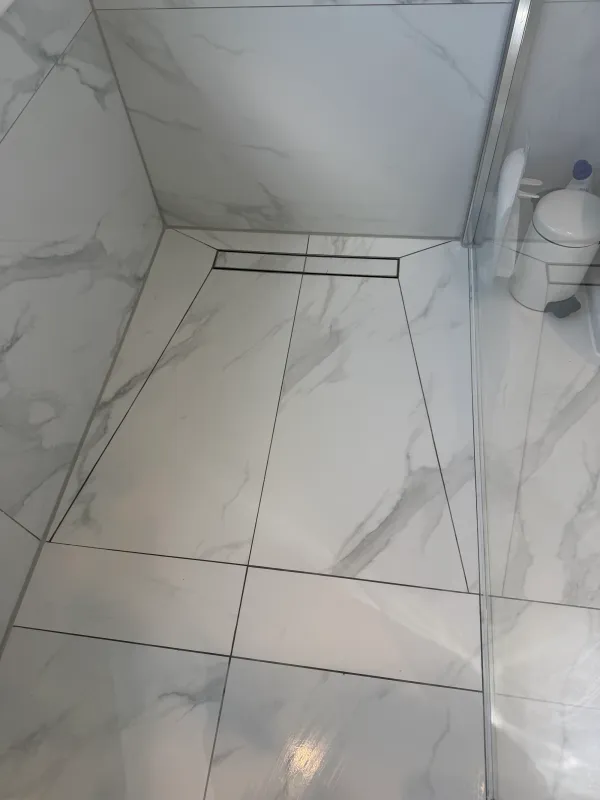Finished marble-effect shower floor and linear drain