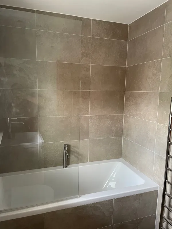 White bath with stone-effect tiled walls