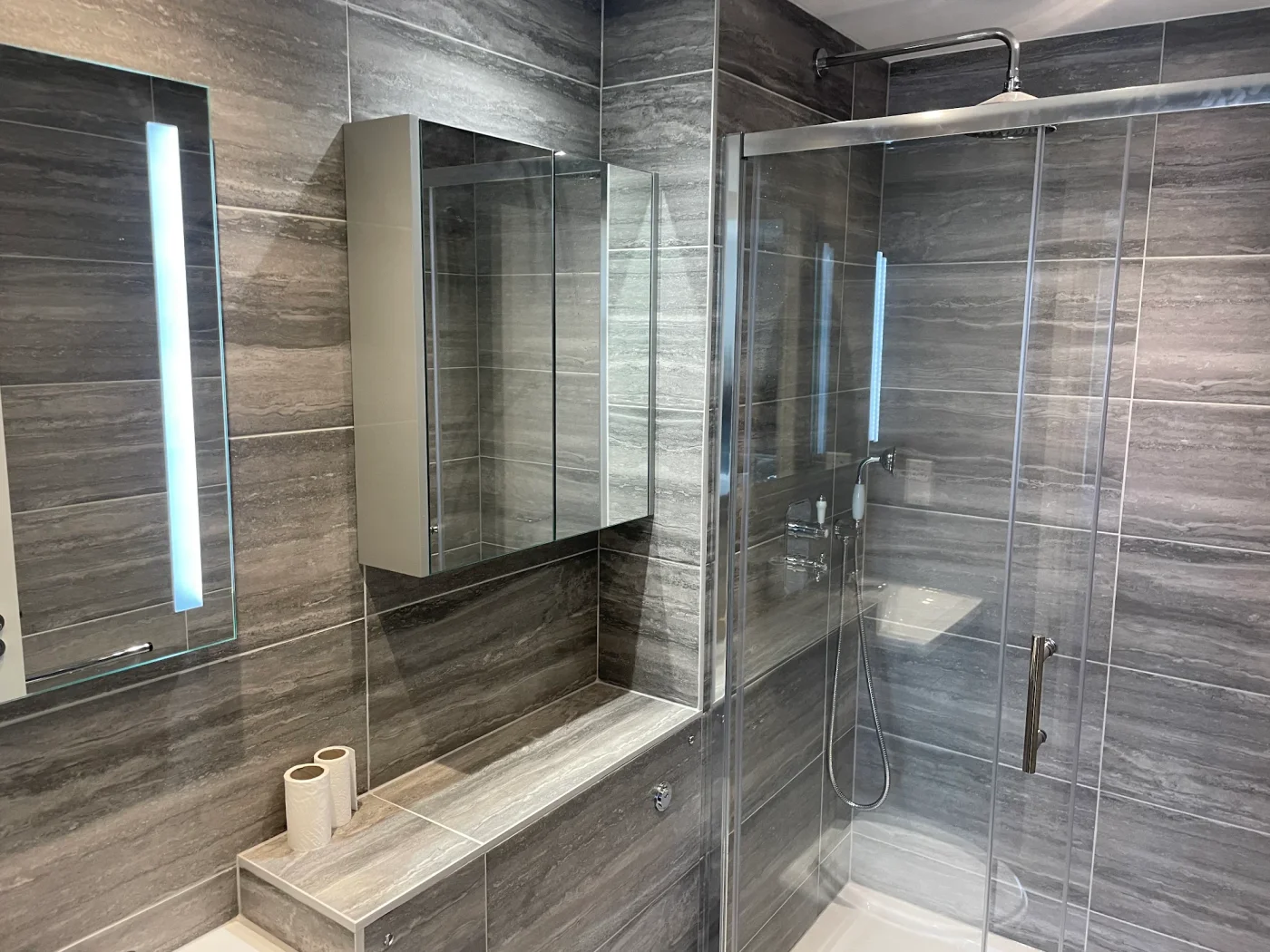 Illuminated mirror and glass shower enclosure